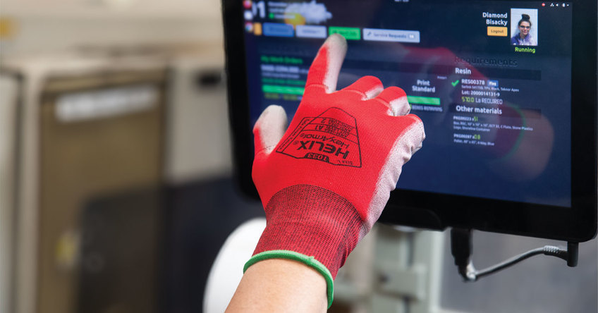 Gloved hand wearing the Helix 1033 with safe finger release technology using a touchscreen device.