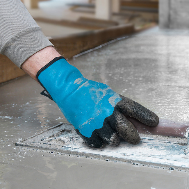 Hands wearing the Helix 3071 water-resistant gloves working with wet concrete.