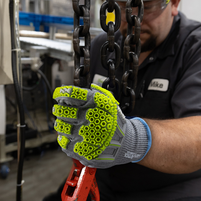 Worker wearing the Helix 3013IMP impact gloves while holding a pipe.