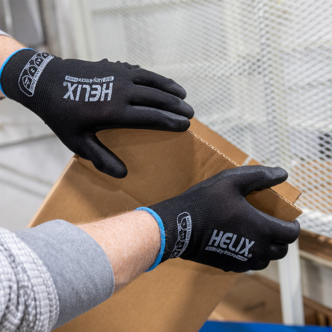 Hands wearing Helix 1030 polyurethane gloves handling boxes.