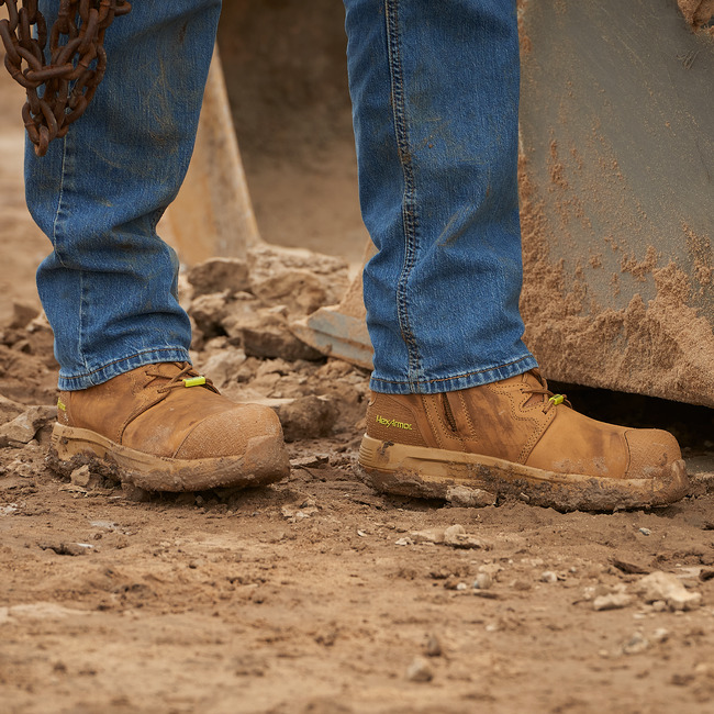 Construction worker standing in Xtend tan 8-inch safety boots on a step. 