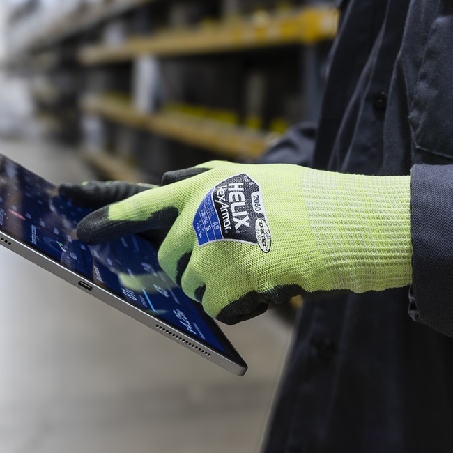 Hi-vis yellow and black Helix 2060 gloves on a worker using a touchscreen tablet