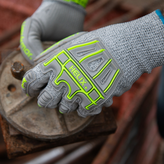 Hands wearing the Helix 1074IMP handling rusty metal parts with ease.