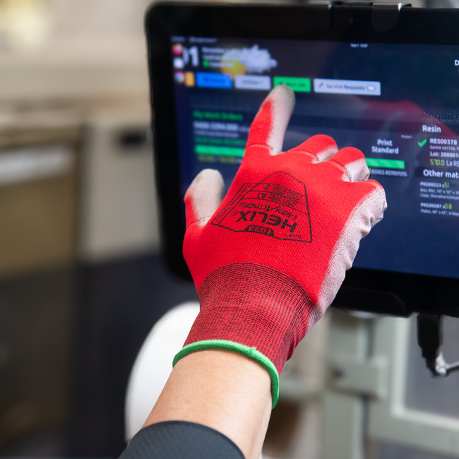 Hand wearing the Helix 1033 touchscreen work gloves while using a screen..