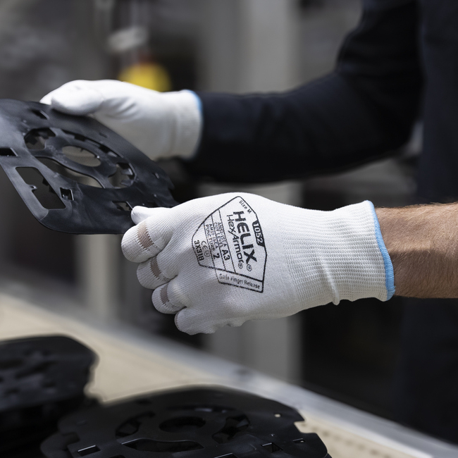 Hands wearing the Helix 1052 mechanic gloves are handling machine parts.