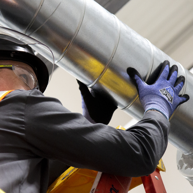 Worker wearing the Helix 2074 cut-resistant gloves working on an HVAC system.