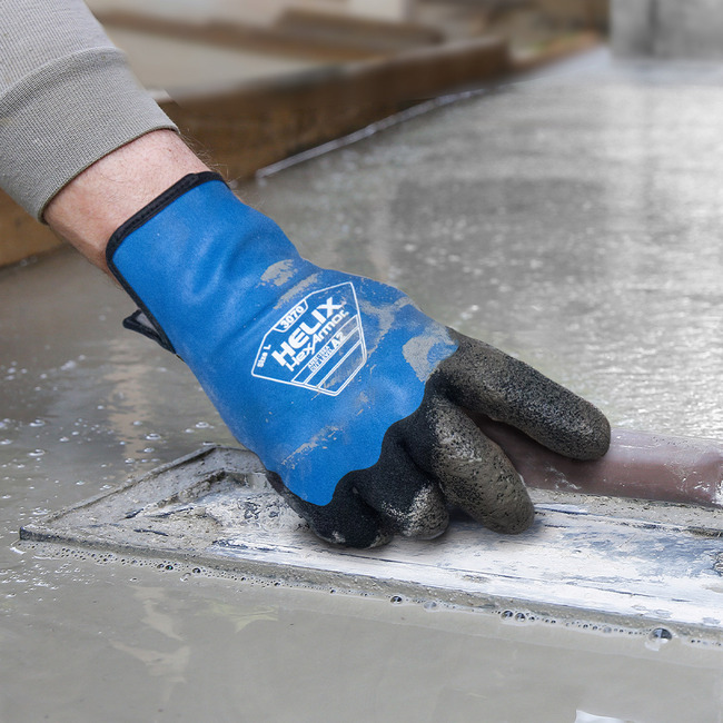 Hands wearing Helix 3070 water-resistant work gloves working with wet cement.