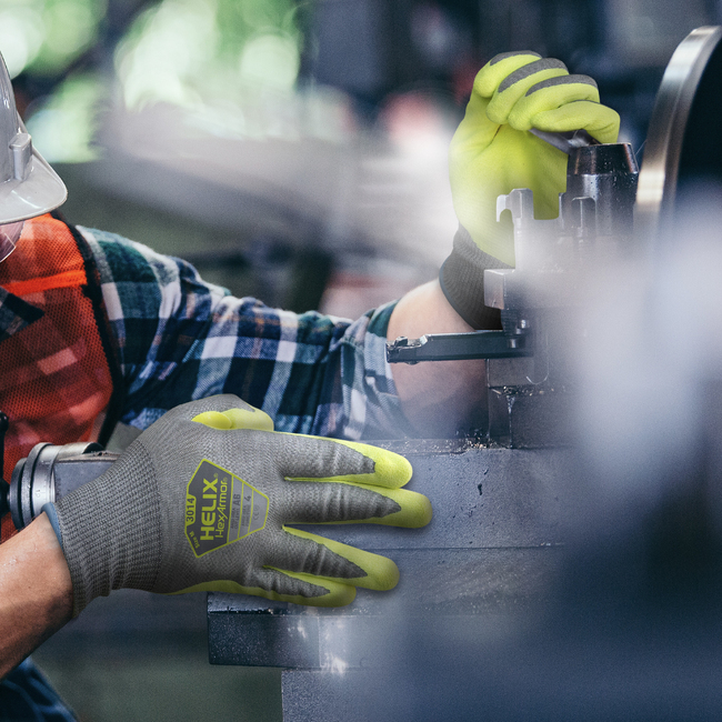 Worker wearing the Helix 3014 hi-vis work gloves while working on a machine.