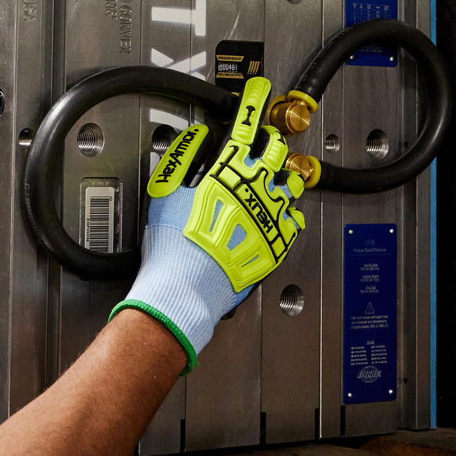 Hands wearing the Helix 3012 abrasion-resistant gloves in an industrial setting.