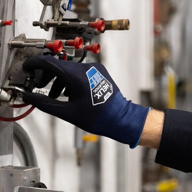 Hand wearing the Helix 1041 nitrile coated gloves adjusting small metal parts.