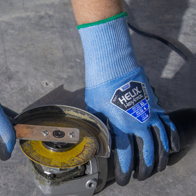 Hands wearing the Helix 3020 puncture-resistant gloves using a tool with sharp edges. 