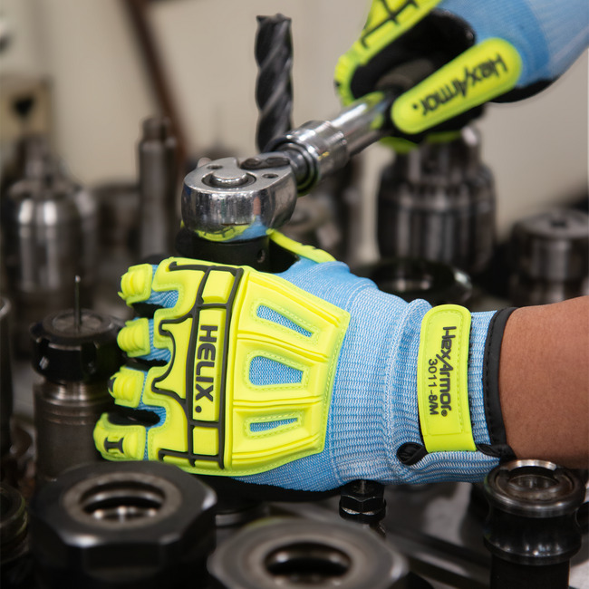 Hands wearing the Helix 3011 impact gloves handing tools.