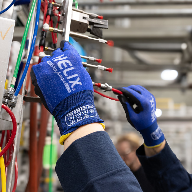 Gloves hands wearing Helix 1032 general purpose work gloves conducting a task that requires high dexterity and precision.